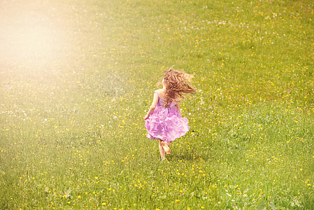 girl in purple sleeveless dress walking on green grass field thumbnail