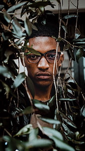 man wearing black framed eyeglasses near green leaf plants thumbnail