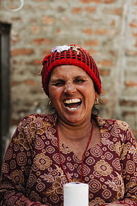 laughing woman in maroon and beige floral top thumbnail