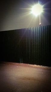 lighted wall lamp near corrugated roof thumbnail