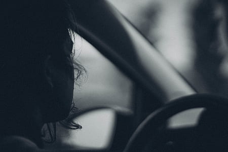 grayscale photo of man driving car thumbnail