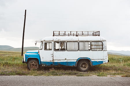 white and teal van parked on grass field thumbnail