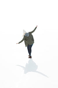 woman standing on white surface while wearing green jacket thumbnail