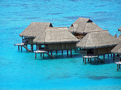gray tipi huts on body of water during daytime thumbnail