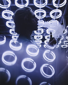 man holding box mod standing in the middle of white light fixtures thumbnail