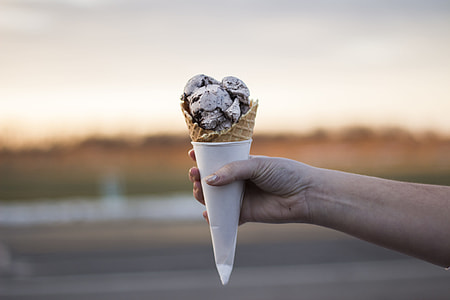 person holding cone of ice cream thumbnail