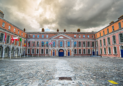 orange and brown painted building with assorted flags thumbnail