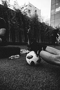 grayscale photo of person's feet on soccer ball thumbnail