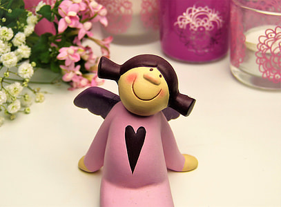 pink ceramic angel figurine on white surface thumbnail