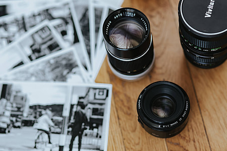 Old Zenit camera and a Canon camera with black-and-white photos on a wooden table thumbnail