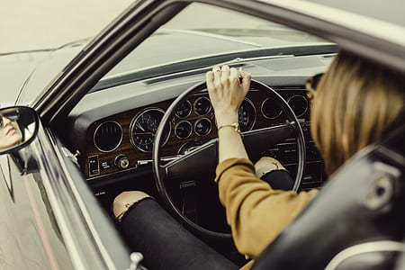 person in brown top driving car thumbnail