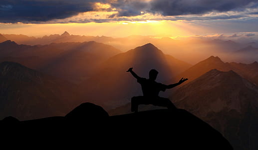Doing tai chi on a mountaintop against a sunset. thumbnail