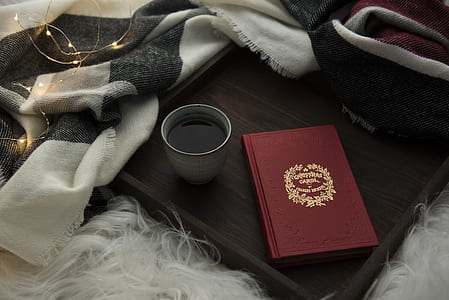 red book beside gray ceramic mug wityh drink thumbnail