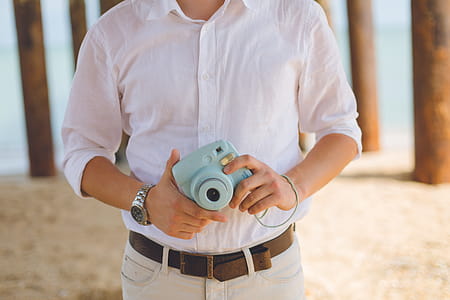 Man Holds Blue Fujufilm Instax Mini Camera thumbnail