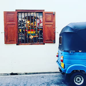 wooden window beside blue auto rickshaw thumbnail