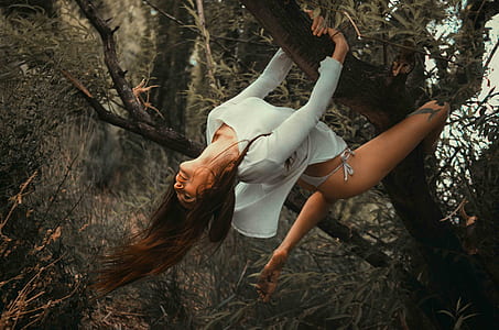 woman wearing white bikini bottoms climbing on tree thumbnail