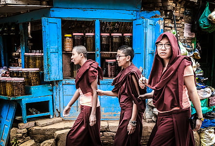 three monks walking beside store thumbnail