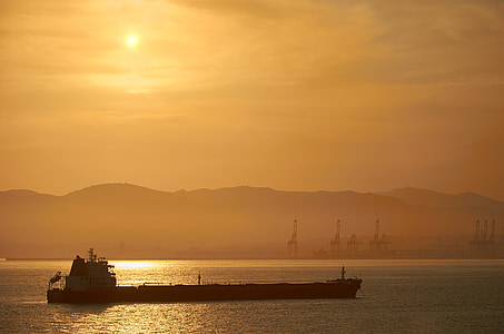 silhouette photography of boat on water thumbnail