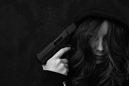 grayscale photo of woman holding gun thumbnail