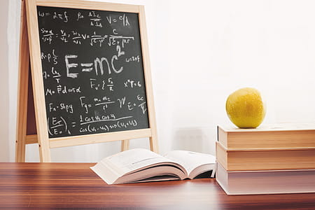 School books with apple on desk over school board background thumbnail