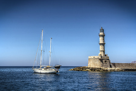 white boat near gray concrete lighthouse at daytime thumbnail