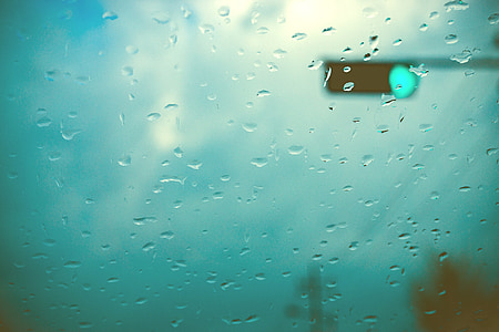 water drops on window overlooking traffic light turning green thumbnail