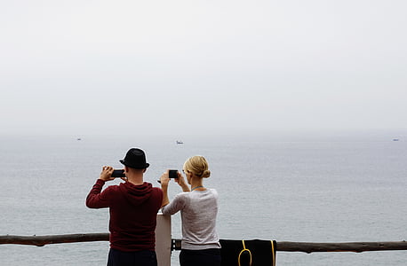 man and woman taking photo at the sea thumbnail