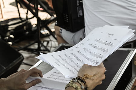 Person Holding White Musical Note Sheets thumbnail