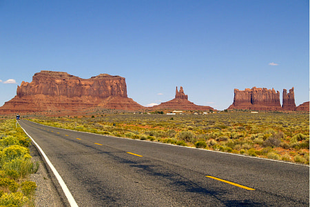 gray asphalt road in the middle of grassland during daytime thumbnail