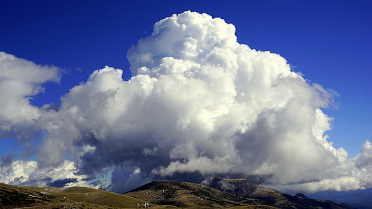 green hill under clouds thumbnail