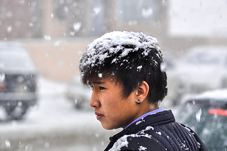 man standing under falling snow thumbnail
