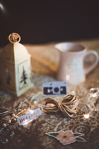 white candle lantern and cream pourer on brown surface thumbnail