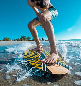 man riding beige and yellow skimboard thumbnail