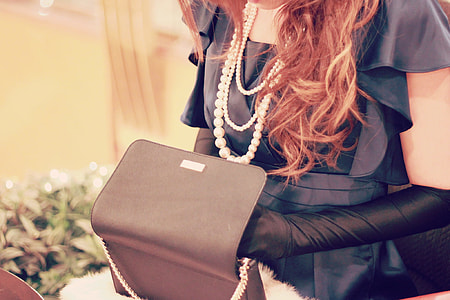 woman in black formal dress with black leather sling bag thumbnail