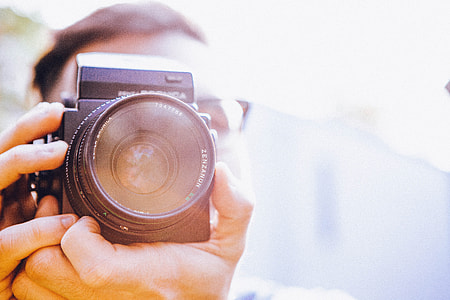 photography of a person holding a camera thumbnail