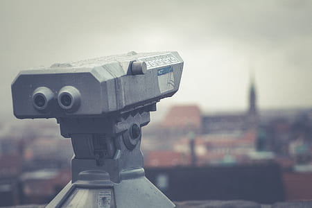 selective focus photography of coin operated telescope racing the city during day thumbnail