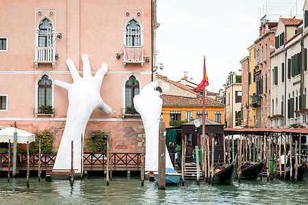 boats on water near hand statue thumbnail