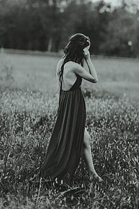 grayscale photo of woman standing on grass thumbnail
