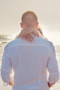 view of wedding couple hugging at the beach thumbnail