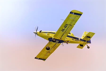 yellow monoplane flying during daytime thumbnail