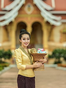woman wearing brown blouse carrying brown wicker basket thumbnail