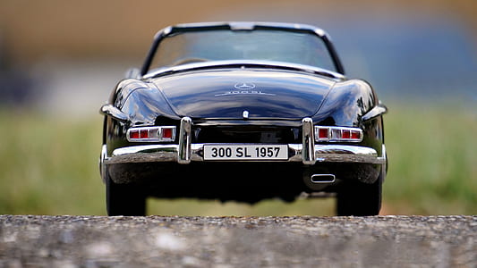 selective focus photography of blue car on gray concrete road at daytime thumbnail