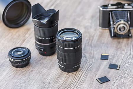 two black camera lens on brown wooden table thumbnail