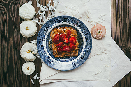 sliced strawberries on round blue and white plate thumbnail