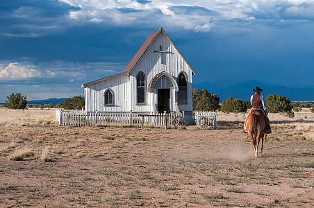 Women riding horse near a small church in Santa Fe, New Mexico thumbnail