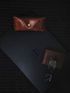 pink leather glasses case on top of gray Dell laptop thumbnail