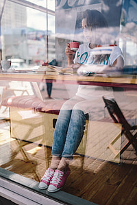 Woman reading book at coffee shop thumbnail