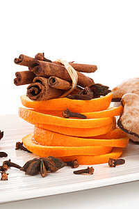 cinnamon rolls on sliced oranges with star anise on beige table thumbnail