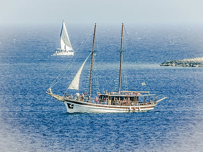 photo of white sail boat on body of water thumbnail