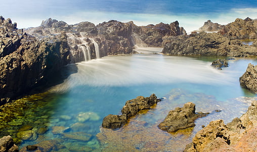 water in between rock formation at daytime thumbnail